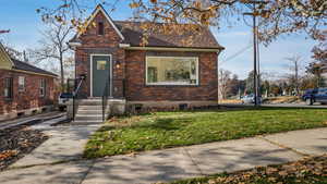 View of front of property with brick siding and a front yard