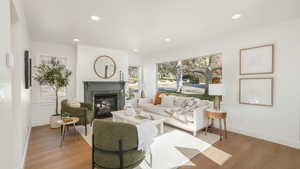 Living room featuring light wood-style flooring, recessed lighting, baseboards, and a high end fireplace