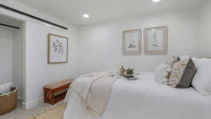 Bedroom featuring recessed lighting, baseboards, carpet, and a barn door