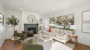 Living area with recessed lighting, a premium fireplace, baseboards, and wood finished floors