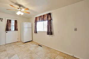 Kitchen with visible vents, baseboards, and a ceiling fan