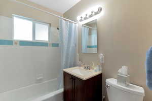 Full bathroom with vanity, toilet, and shower / bath combo