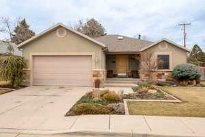 Ranch-style house with stucco siding, concrete driveway, and an attached garage