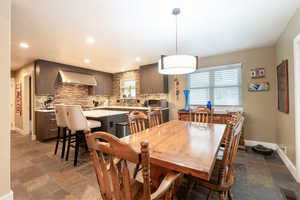 Dining area featuring stone finish floor, recessed lighting, and baseboards