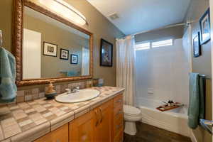 Bathroom with vanity, visible vents, tile patterned flooring, toilet, and shower / tub combo with curtain