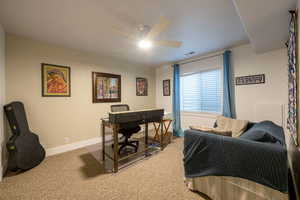 Carpeted bedroom with ceiling fan and baseboards