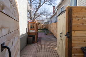 View of property exterior featuring a patio, a chimney, and a fenced backyard