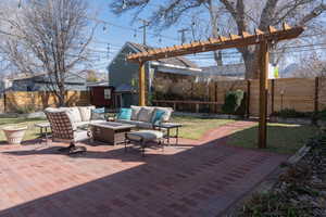 View of patio with an outdoor living space with a fire pit, a fenced backyard, and a pergola