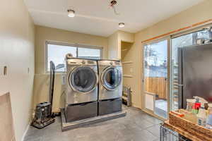 Laundry area featuring tile patterned flooring, laundry area, and washing machine and clothes dryer