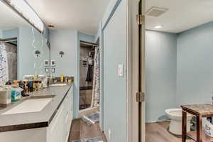 Full bath featuring double vanity, visible vents, a stall shower, and a sink