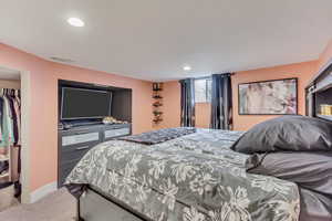 Carpeted bedroom with recessed lighting, visible vents, and baseboards