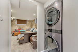 Washroom featuring recessed lighting, carpet floors, stacked washer and clothes dryer, and laundry area