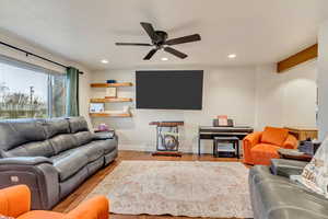 Living area featuring recessed lighting, baseboards, wood finished floors, and a ceiling fan