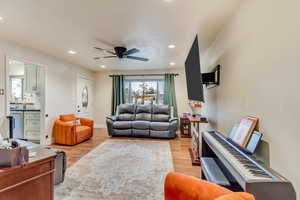 Living room with recessed lighting, baseboards, light wood-style floors, and a ceiling fan