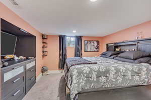 Carpeted bedroom featuring visible vents and baseboards