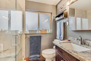 Full bathroom with a shower stall, vanity, and toilet