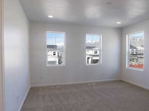 Unfurnished room featuring carpet floors, baseboards, a textured ceiling, and recessed lighting