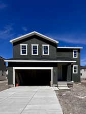 View of front of home with stucco siding, concrete driveway, and a garage