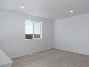 Spare room with recessed lighting, light carpet, and baseboards