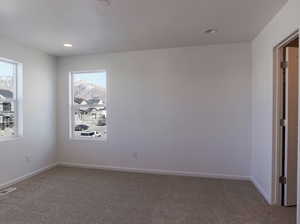 Carpeted empty room featuring baseboards and recessed lighting