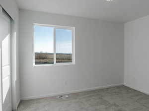 Carpeted empty room with baseboards