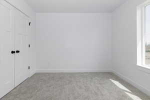 Unfurnished room featuring baseboards and light colored carpet