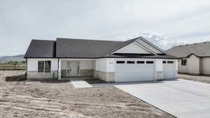 Ranch-style home with a garage, a shingled roof, driveway, and stone siding