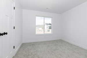 Spare room featuring baseboards, carpet flooring, and visible vents