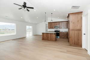 Kitchen with visible vents, a center island, vaulted ceiling, open floor plan, and stainless steel appliances