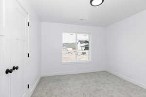 Spare room featuring carpet floors, baseboards, and visible vents