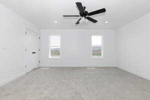 Carpeted spare room featuring baseboards, a ceiling fan, and recessed lighting