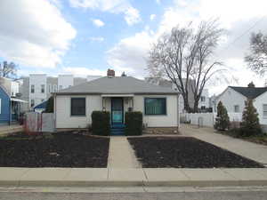 Bungalow-style house with a shingled roof and fence