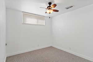 Unfurnished room featuring baseboards, carpet, visible vents, and ceiling fan