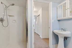 Full bathroom featuring a stall shower and a sink