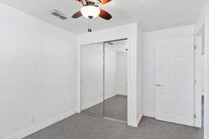 Unfurnished bedroom featuring a ceiling fan, baseboards, visible vents, carpet floors, and a closet