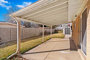 View of patio with an outdoor structure, a fenced backyard, and a shed