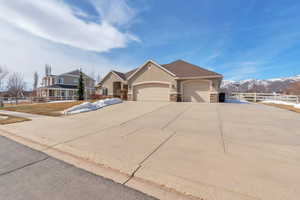 View of front of house with fence, an attached garage, stucco siding, concrete driveway, and stone siding