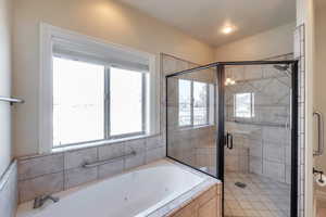 Bathroom featuring a shower stall and a tub with jets