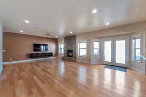 Unfurnished living room featuring recessed lighting, baseboards, light wood-style floors, and a fireplace