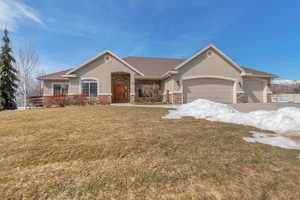 View of front of house with stone siding, stucco siding, and a garage