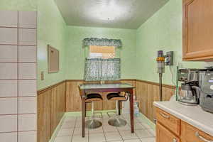 Kitchen featuring a wainscoted wall, wooden walls, and light countertops