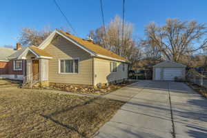 View of property exterior featuring an outbuilding, a yard, fence, and a garage