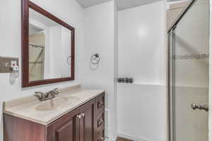 Bathroom featuring tiled shower and vanity