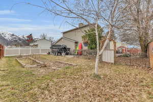 View of yard featuring a vegetable garden and fence