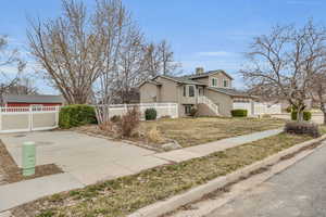 View of home's exterior featuring concrete driveway and fence