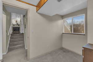 Spare room featuring stairway, visible vents, baseboards, and carpet