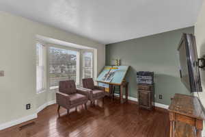 Sitting room featuring visible vents, baseboards, and wood finished floors