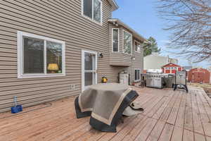 Wooden terrace with an outbuilding, area for grilling, and a storage shed