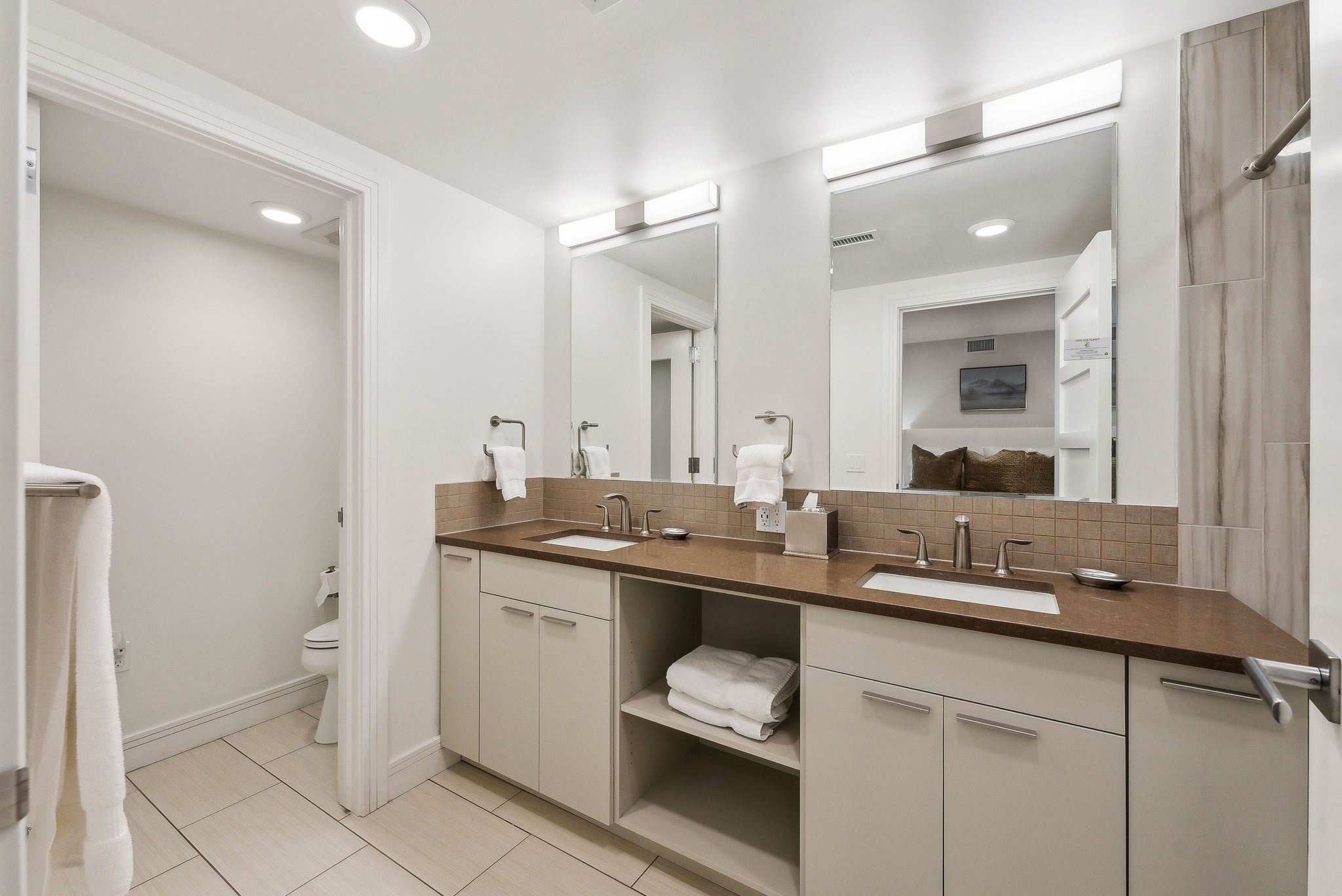 Bathroom with a sink, tasteful backsplash, double vanity, and toilet