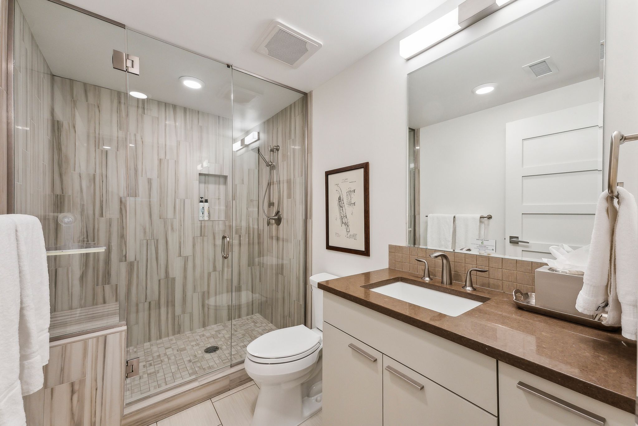 Full bath with visible vents, a shower stall, toilet, and vanity
